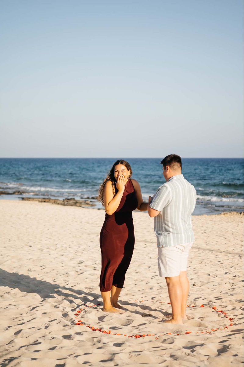 Andrea laughing on the beach moments after the proposal